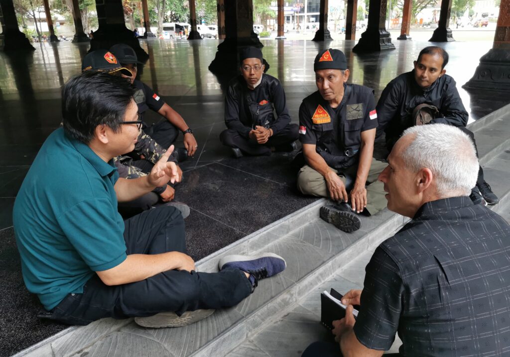 Paulus Hartono (left) and Jonathan Bornman (front, right) are talking with Sony Rusmanto (center) and other members of Hezbollah in Solo, Indonesia while filming.