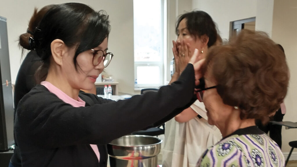 Ayuno anoints Tserenjamts during the closing blessing ritual at the Sister Care seminar. — Sister Care