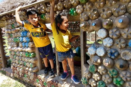 ​Children at Samuelito Daycare center prior to the pandemic enjoy climbing on their play house made of recycled materials. Families helped gather the materials and the center won a contest in the city of Santa Cruz for their environmentally friendly construction. Now some of the same children