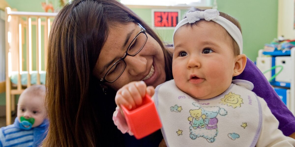 ​2007-08 Service Adventure participant Tania LaMotte plays with baby Aubrey at Learn and Play Child Development Center in Albuquerque. Learn and Play Child Development Center was one of the many service placments that welcomed Service Adventure participants over the years in the Albuquerque community. Photo by Cara Rufenacht.