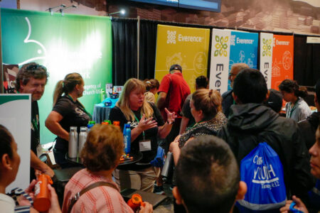 Susan Nisly (center) talks with visitors at the MMN booth on Tuesday