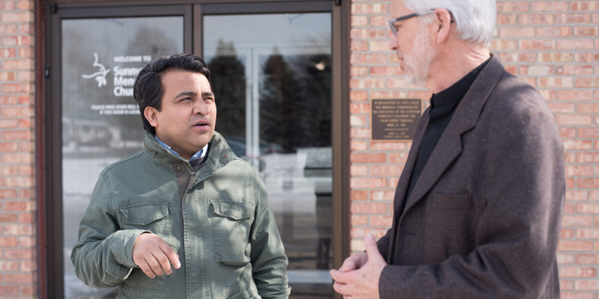 Naun Cerrato and Charles Geiser talk outside Sunnyside Mennonite Church. Photo by David Fast.