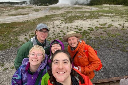 Neeltje Sandersfeld, Micah Wenger, Shelby and Travis Clarke, and Malia Bauman in front. at Yellowstone National Park by Old Faithful