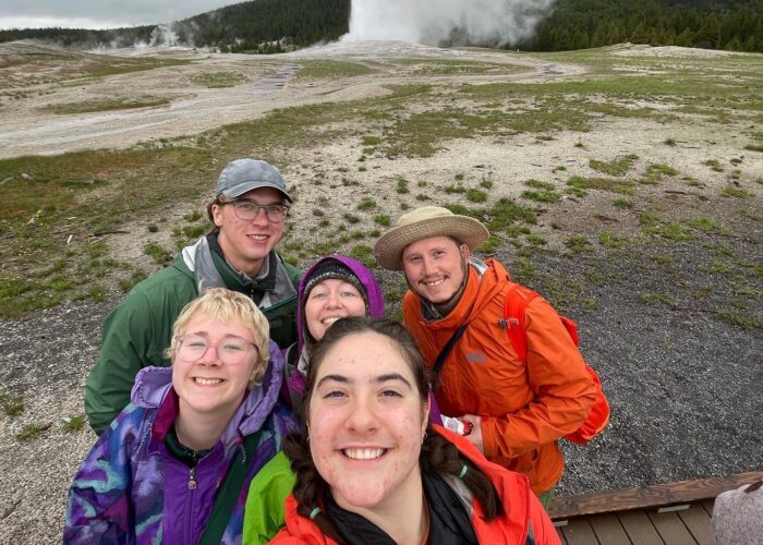 Neeltje Sandersfeld, Micah Wenger, Shelby and Travis Clarke, and Malia Bauman in front. at Yellowstone National Park by Old Faithful