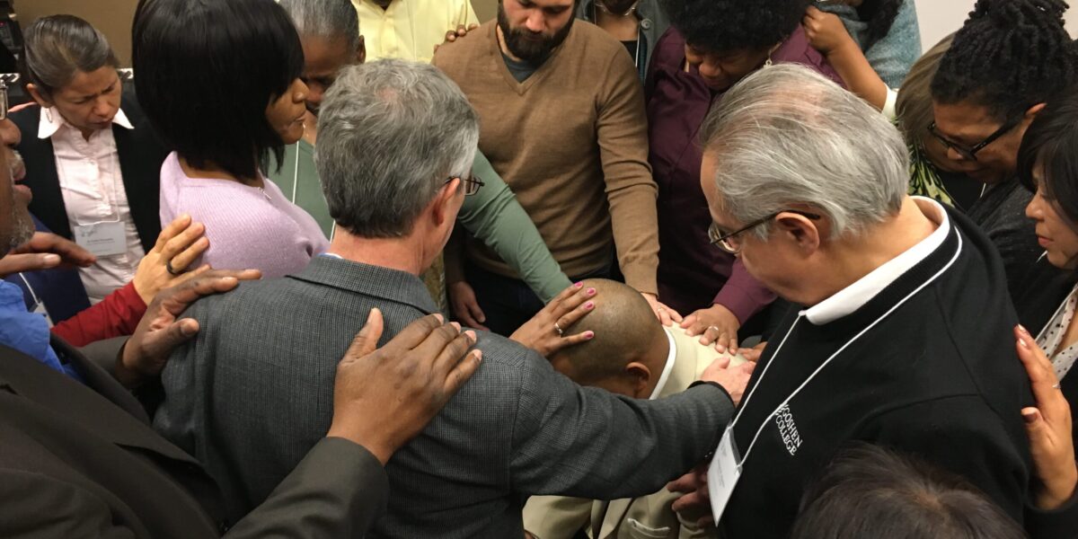 Fellow participants at Hope for the Future 2018 pray over Glen Guyton