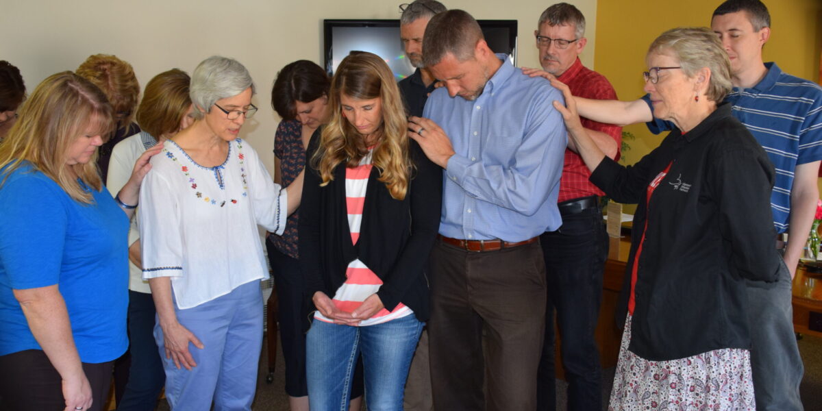 ​Mennonite Mission Network staff members pray with DeeDee and Mark Landes during a May 29 chapel in Newton