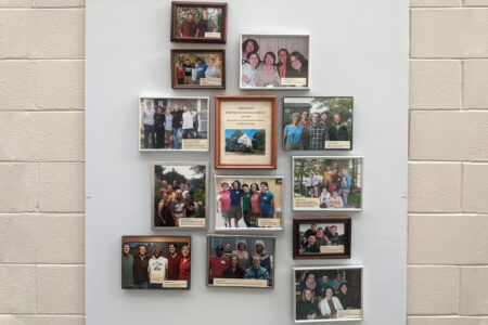 ​Photos of the MVS unit participants hang in a foyer at Prairie Street Mennonite Church. Photo by Zachary Headings.