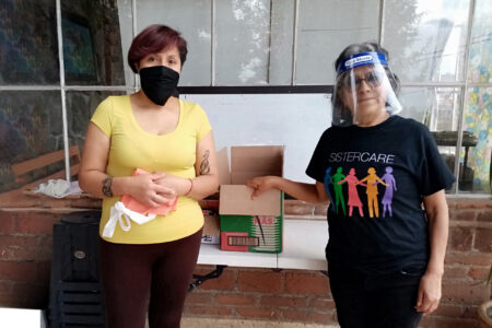 ​Ofelia García (right) enlists the help of a neighbor Elvia (left) in delivering food and other basic supplies in the neighborhood during the pandemic. Photo by Victor Pedroza.