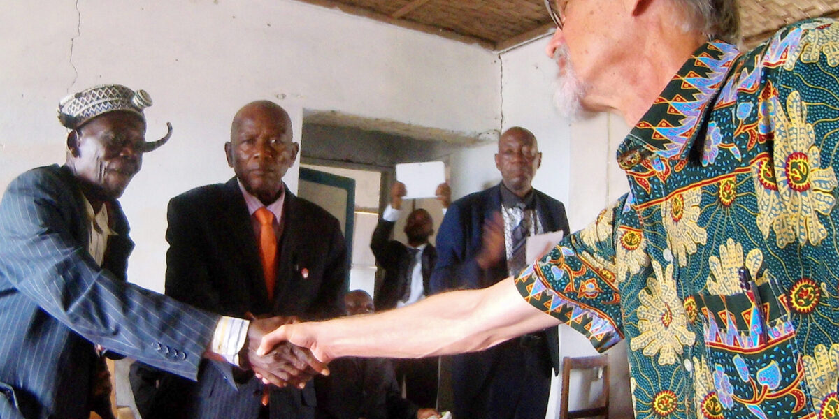 One of the traditional dignitaries from the surrounding region shakes Rod Hollinger-Janzen's hand during the ceremony of confession and reconciliation in Kandale