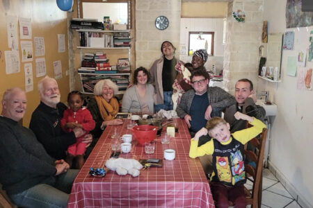 ​Heba (standing center) and Rachel and Joseph Givens (seated center) share table fellowship with board members