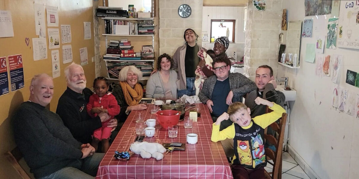 ​Heba (standing center) and Rachel and Joseph Givens (seated center) share table fellowship with board members