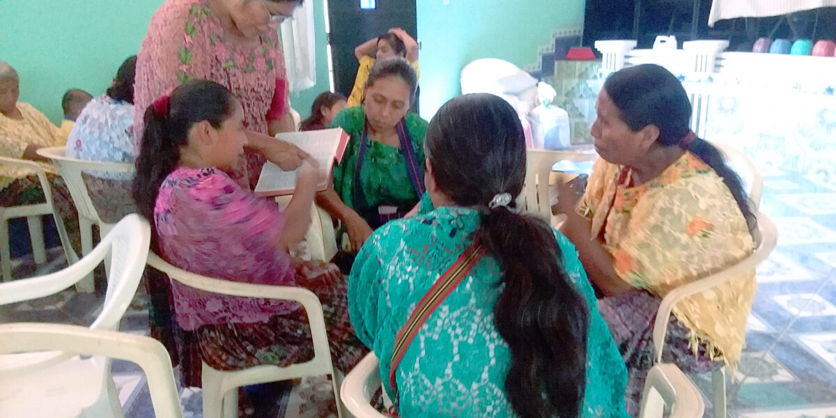 ​Kekchi leader Julia Xol (standing) helps four Kekchi leaders at Nuevo Chintun Mennonite Church in the Tucuru region in Guatemala to study a biblical text on the Holy Spirit. The leaders pictured here will then present the material at a Bible study day for Kekchi women at one of the Kekchi Mennonite churches. Photo by Deb Byler. 