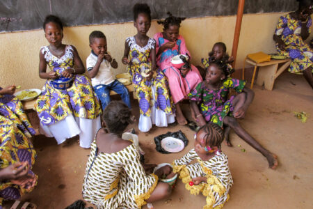 ​Children in Burkina Faso commune together around shared plates of food. Photo provided.