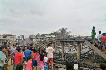 ​Adults and children living on Isla Iquitos in Peru survey the damage at the site where their church and five houses burned to the ground the night of August 29. Children stand on the stairs that once led to their space for worship and learning. Photo by Juan Carlos Moreno.