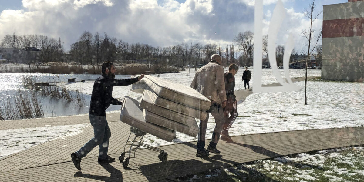 ​Students at LCC International University in Lithuania move mattresses to set up the gymnasium as a quarantine zone. Photo by Marlene Wall.