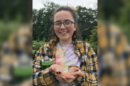 ​2018 Youth Venture participant Selah Judge holds a butterfly at the Menno Village farm in Naganuma