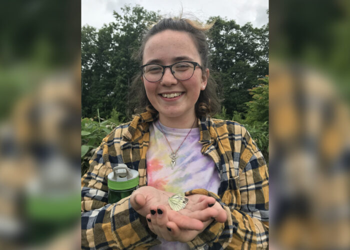 ​2018 Youth Venture participant Selah Judge holds a butterfly at the Menno Village farm in Naganuma