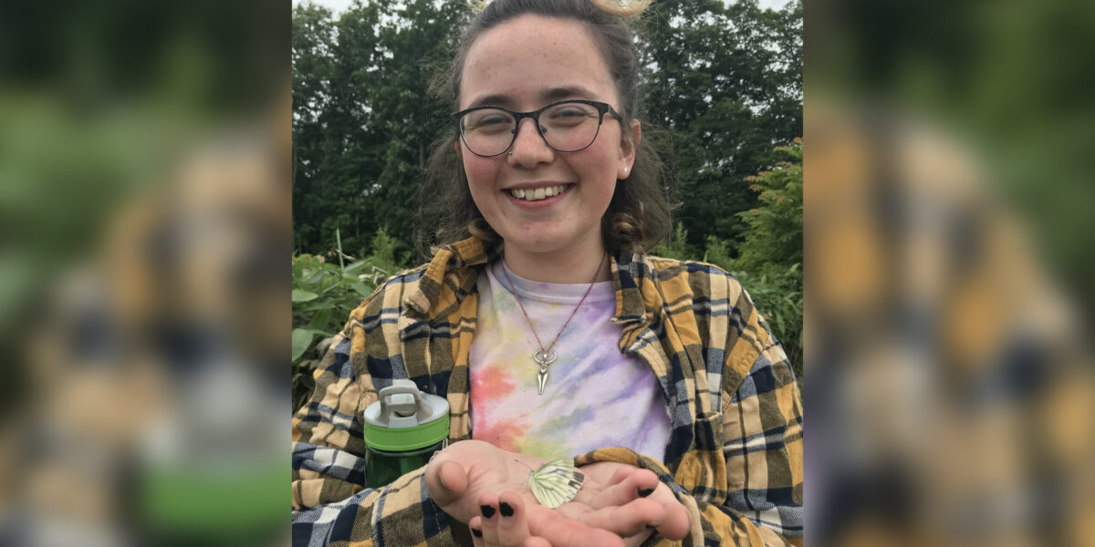 ​2018 Youth Venture participant Selah Judge holds a butterfly at the Menno Village farm in Naganuma