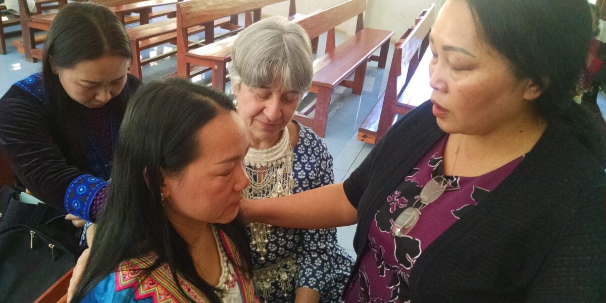 ​Memee Yang (right) prays for Song Vang at the Thailand Sister Care seminar held Jan. 20-22