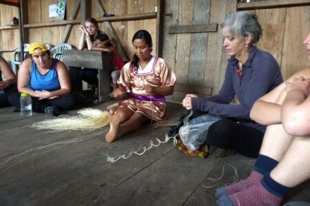 ​Gladys Mendua demonstrates how to weave a bag out of palm fibers to a Goshen College class. Photo provided.