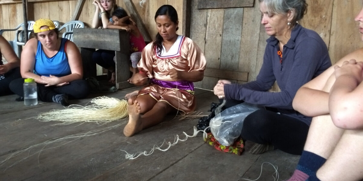 ​Gladys Mendua demonstrates how to weave a bag out of palm fibers to a Goshen College class. Photo provided.