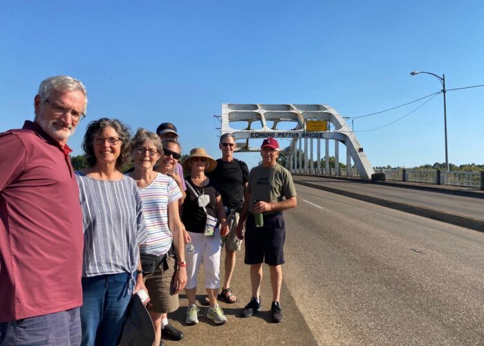 Members of Community Mennonite Church's Just Peace Pilgrimage group stand before the Edmund Pettus Bridge in Selma, Alabama. From left to right: Art Stoltzfus, Meribeth Kraybill, Betty Shenk, Rene Hostetter, Isaac Witmer, Ruth Zimmerman, Keaton Shenk, and Earl Zimmerman. Photo provided.