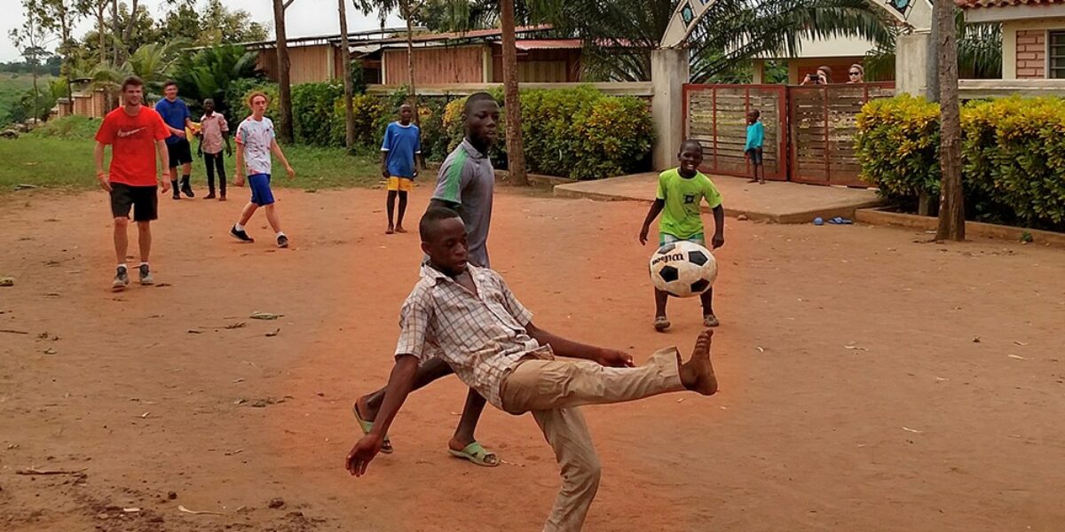 Armel Gladja and Gildas Akpo kick the ball during an afternoon soccer game between Youth Venture participants and children