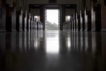 Desaturated image of empty church aisle.