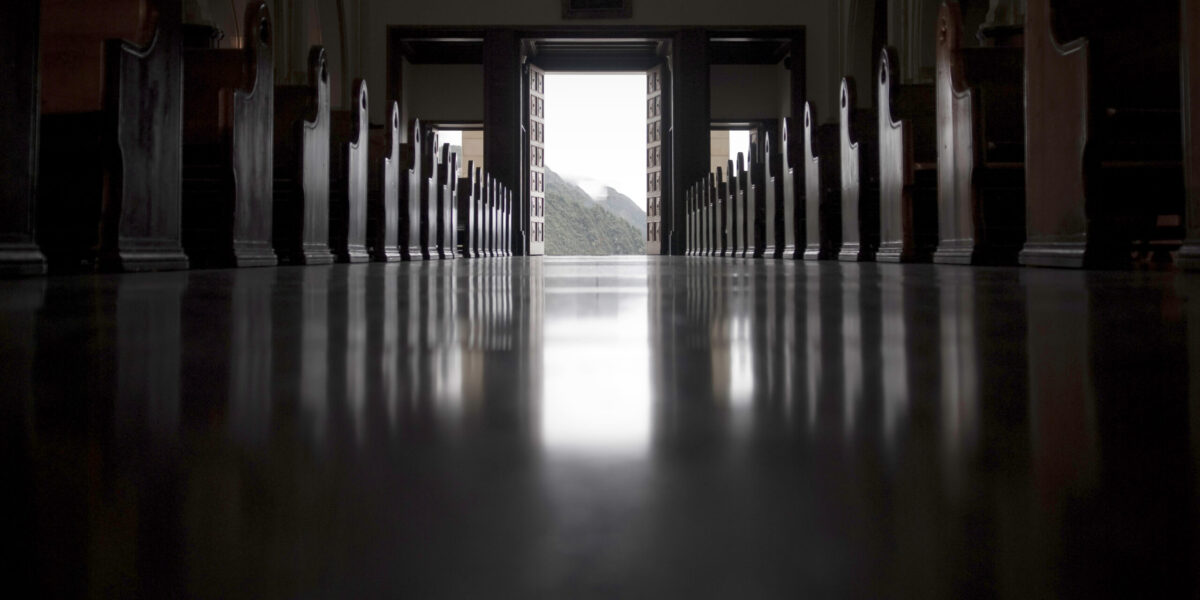 Desaturated image of empty church aisle.