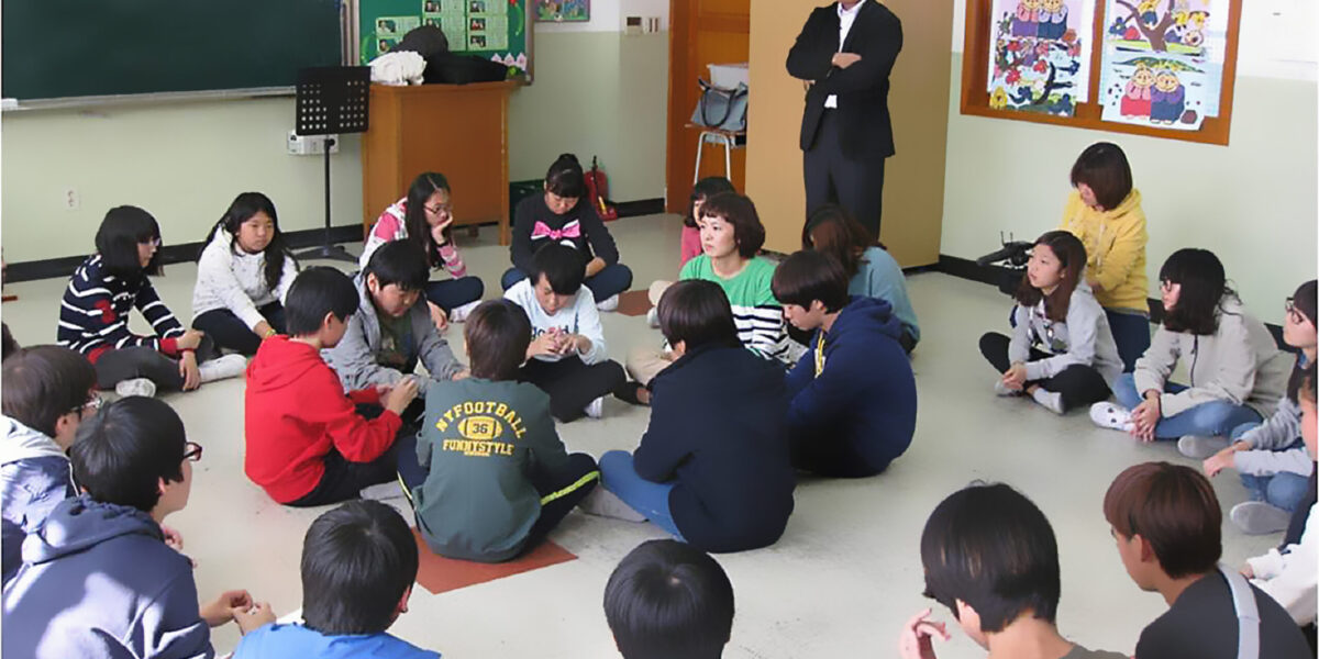 ​Jae Young Lee leads a restorative discipline class at an elementary school in Seoul. Students directly involved in bullying sit in the middle circle. Other classmates sit in the outside circle.  Photo by KOPI staff.