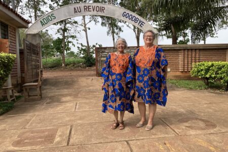 From left, Maria and Barb Thuma pose after Sunday church service on their last day in Allada. Their bespoke dresses were gifted to them the day before as a going-away present from La Casa Grande Director Bienvenu Kadja and his wife Chimene Kadja, a member of the staff.